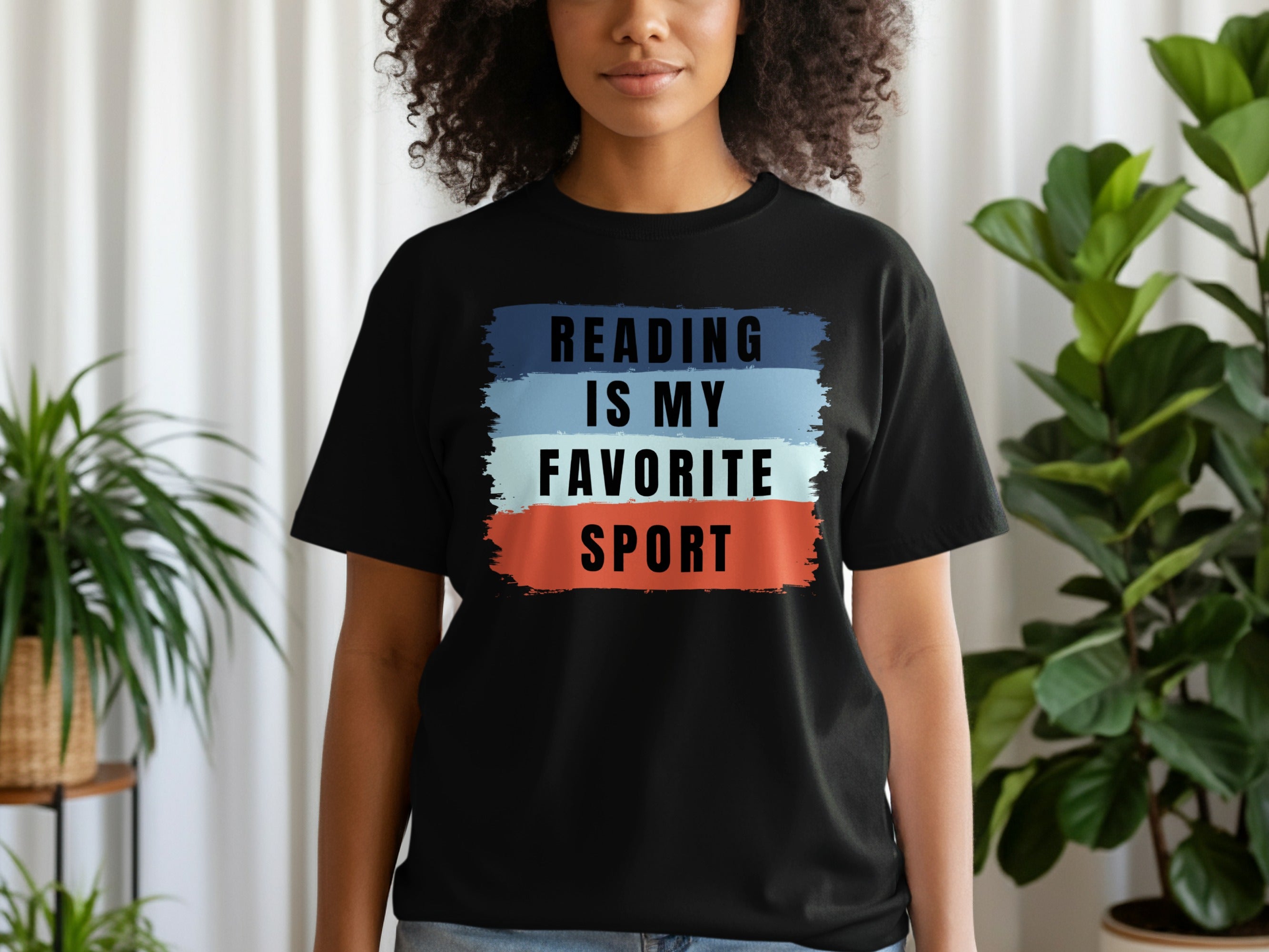 Black t-shirt with text "Reading is my favorite sport" on colorful brush strokes.
