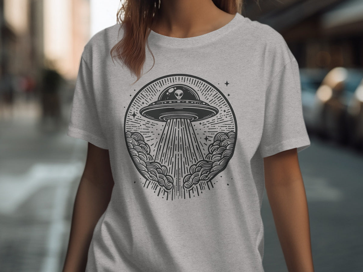 Grey t-shirt with a circular black graphic of a UFO with an alien and a beam of light.