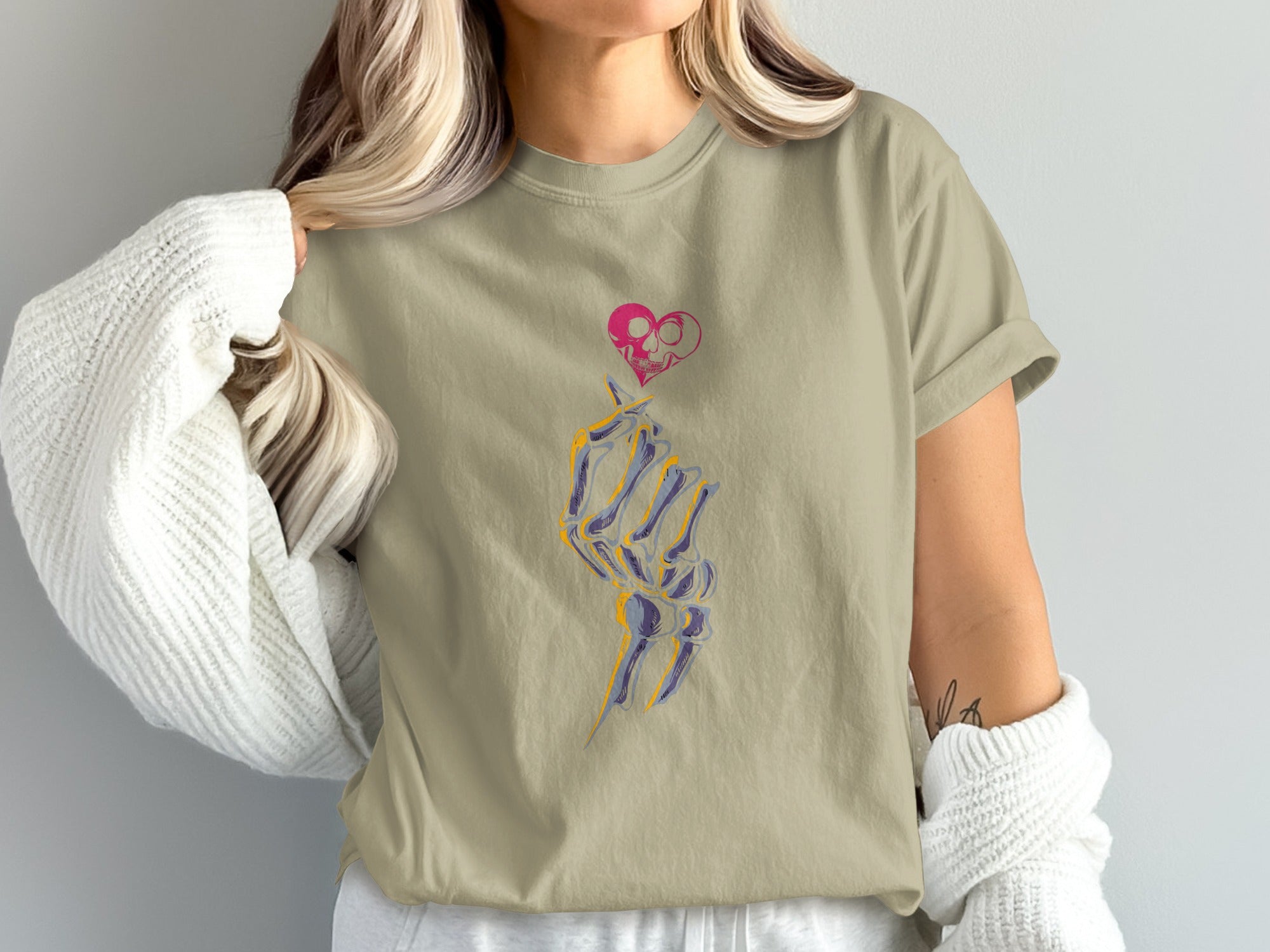 T-shirt with skeleton hand, pink skull heart, and purple blue graphic.
