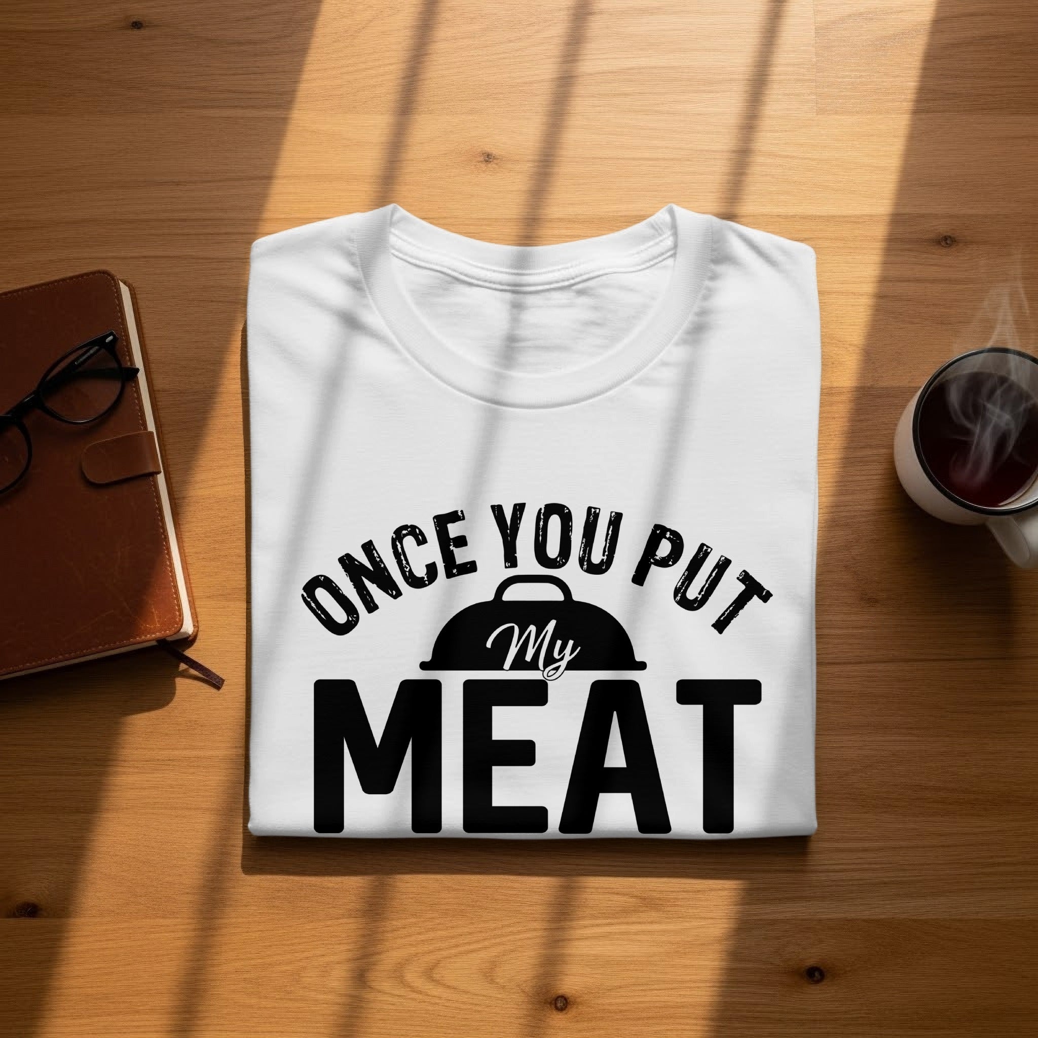 White t-shirt with text "ONCE YOU PUT My MEAT" and a grill icon.