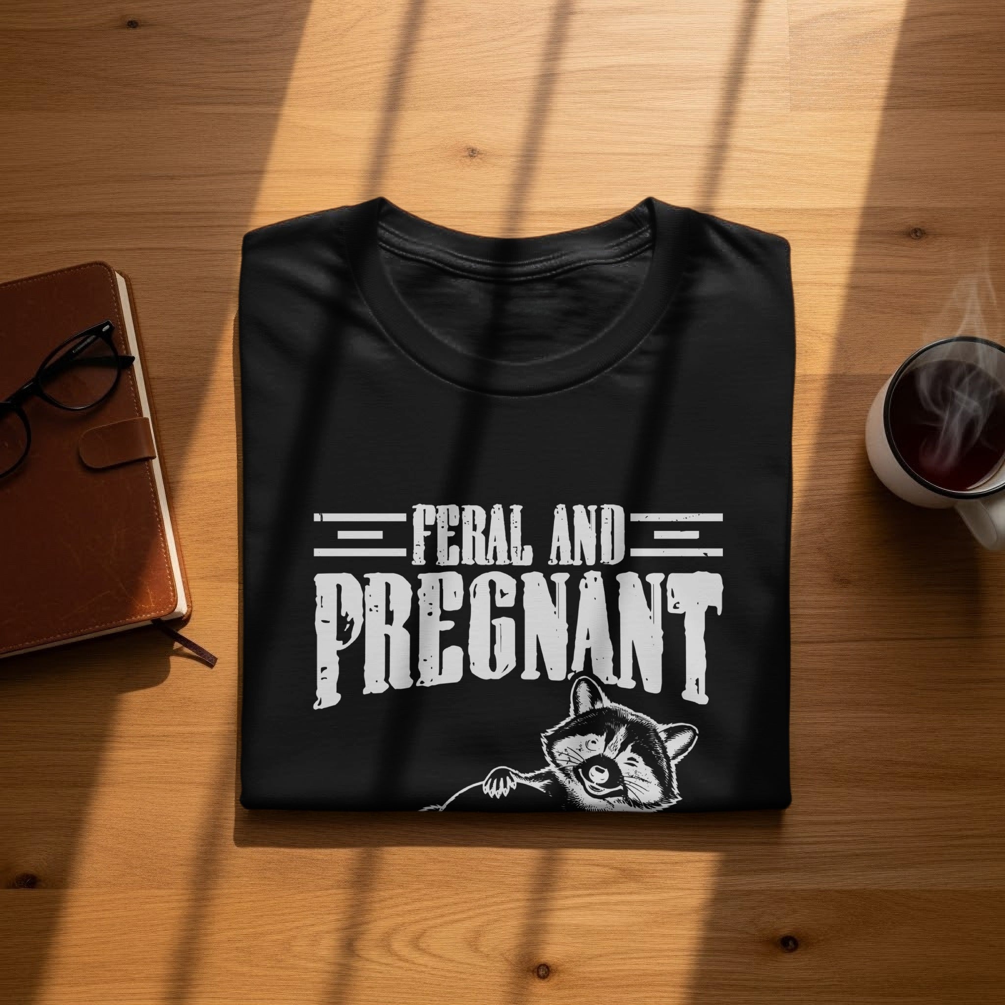 Black t-shirt with "Feral and Pregnant" text and a raccoon illustration.