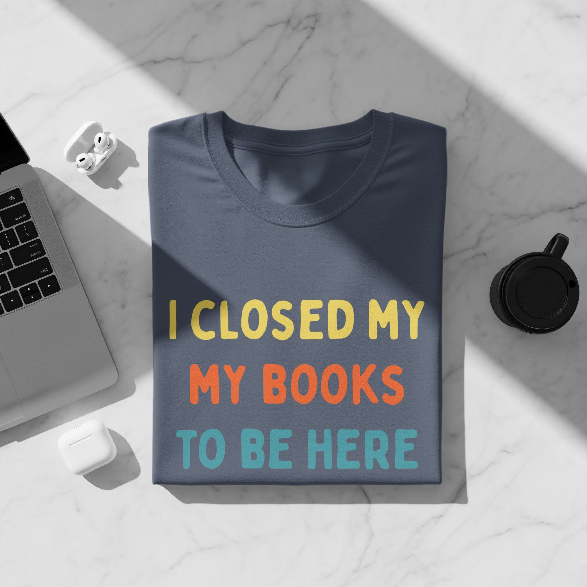 Dark blue t-shirt with "I CLOSED MY MY BOOKS TO BE HERE" text.