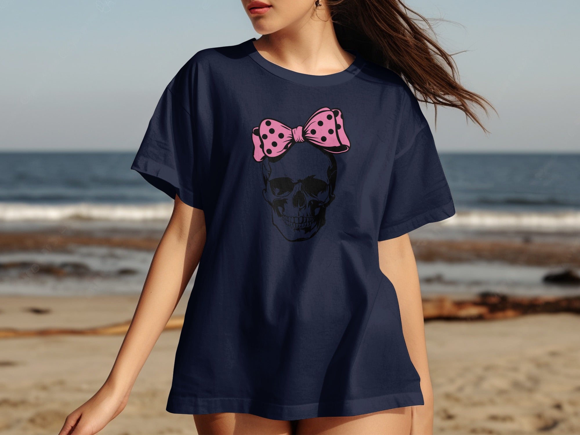 Navy t-shirt with a black skull wearing a pink polka dot bow graphic.