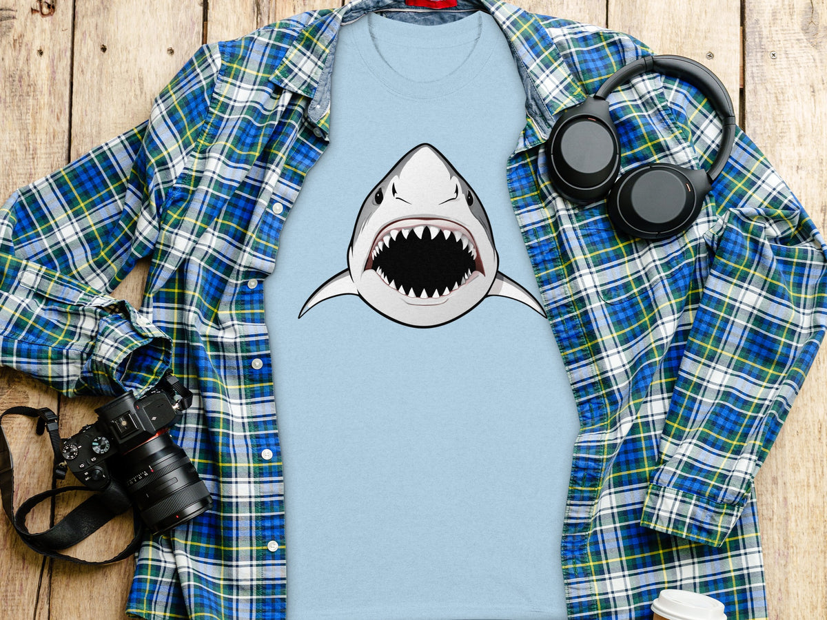 Light blue t-shirt with a fierce shark graphic, layered under a plaid shirt.