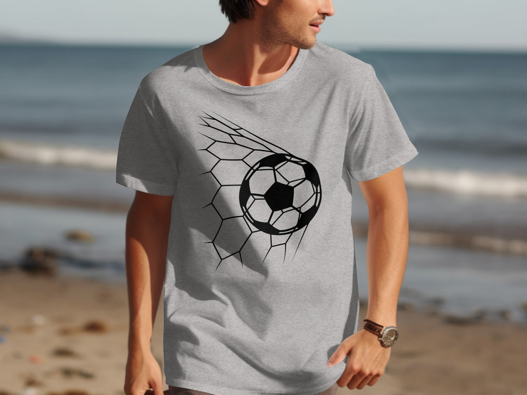 Grey t-shirt with a black soccer ball design breaking through a net.