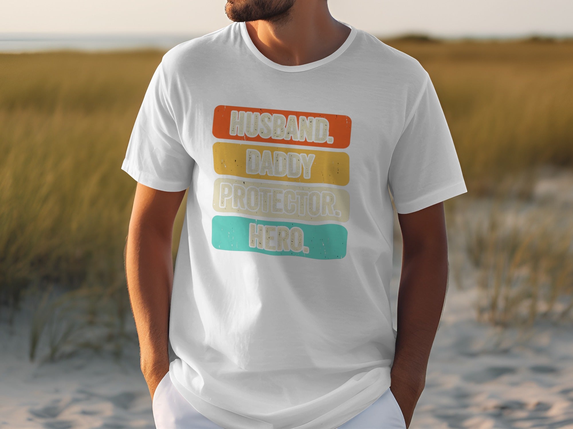 White t-shirt with text Husband, Daddy, Protector, Hero on colored stripes.