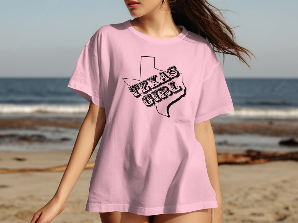 Pink t-shirt with black outline of Texas and "TEXAS GIRL" text.