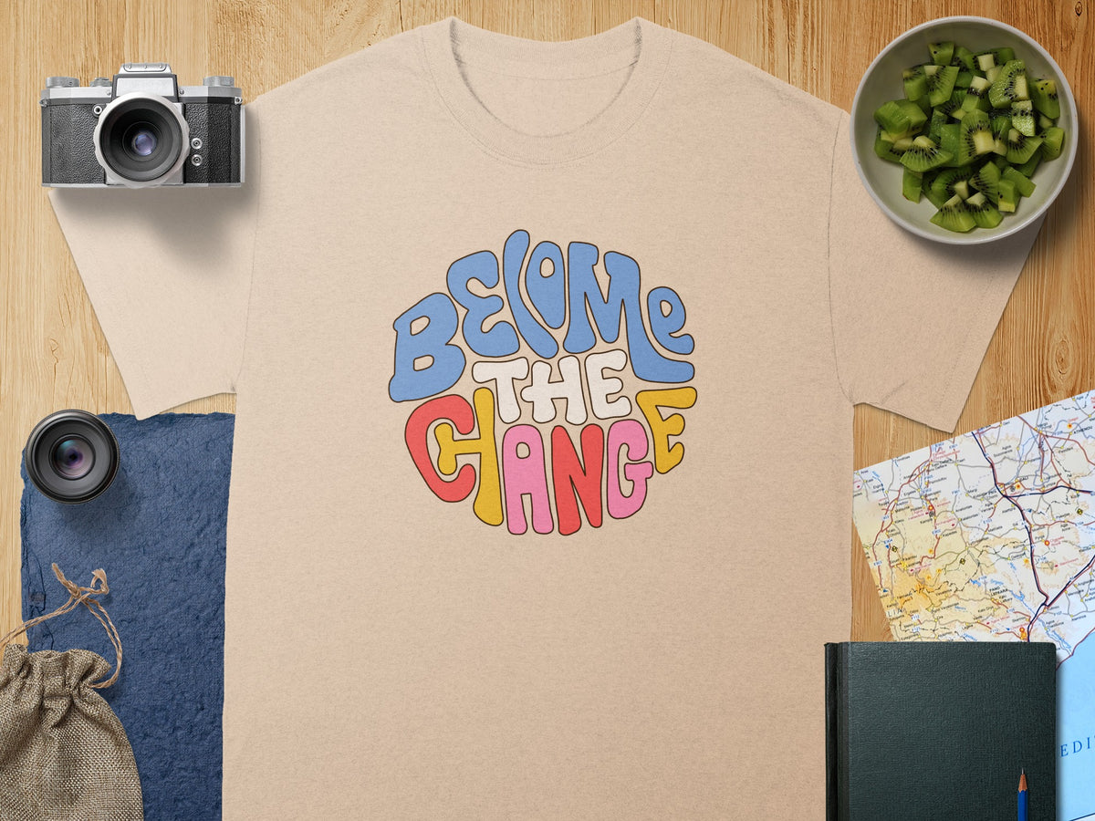 Light tan t-shirt with "BECOME THE CHANGE" graphic in retro font.