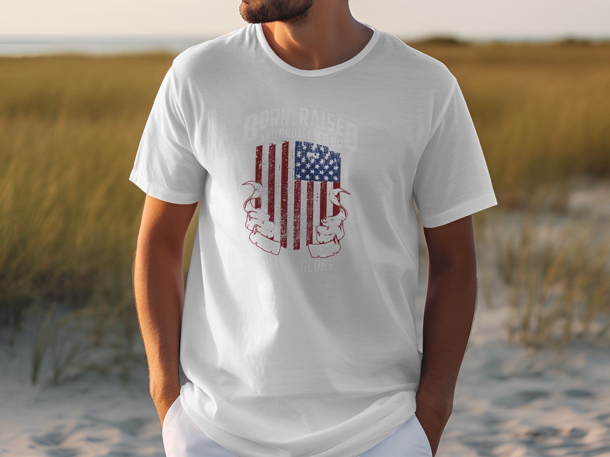 White t-shirt with distressed American flag and text "Born, Raised, and Protected By Guns & Glory."