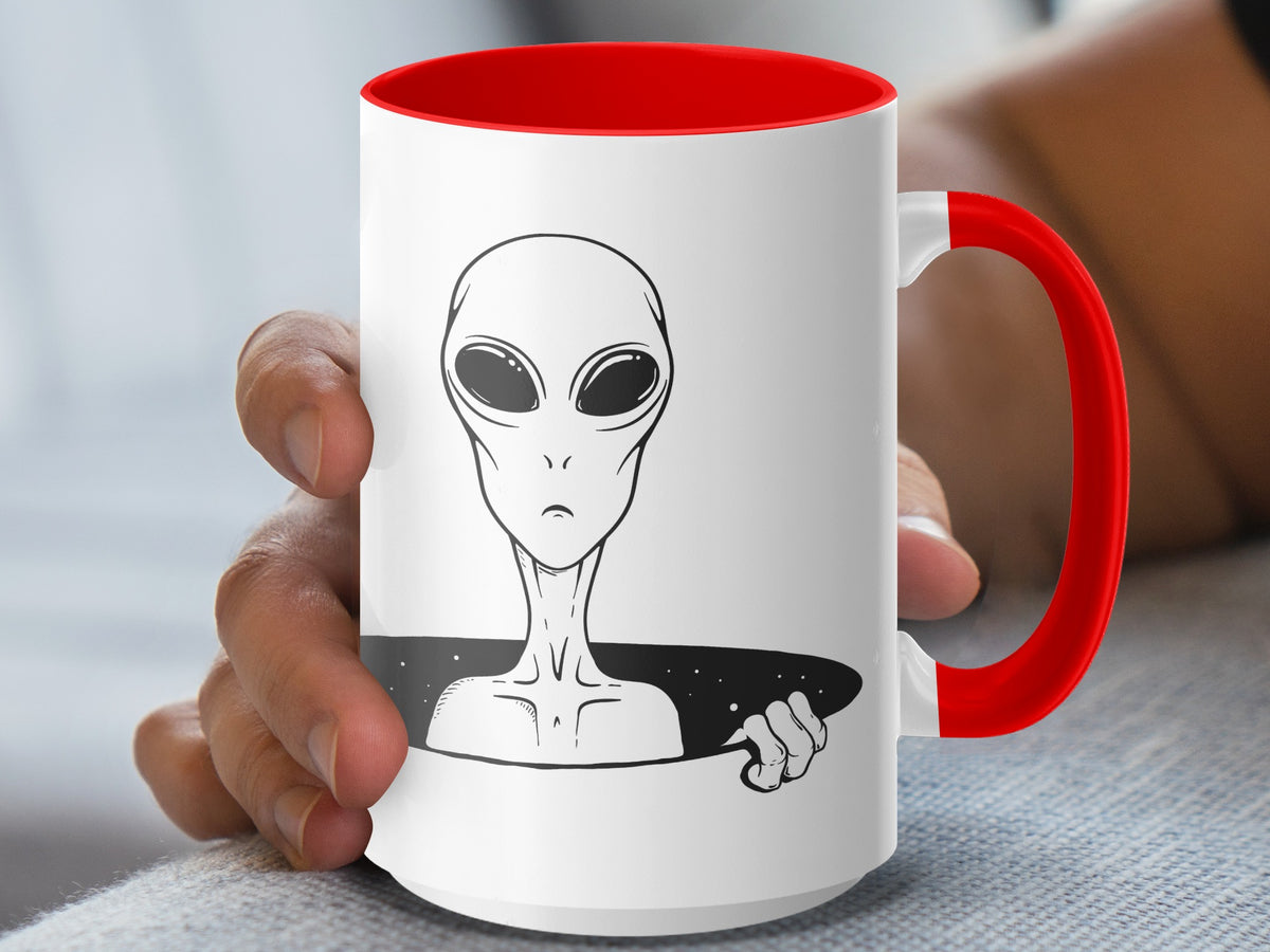 White mug with red handle and interior, featuring a black and white alien illustration.