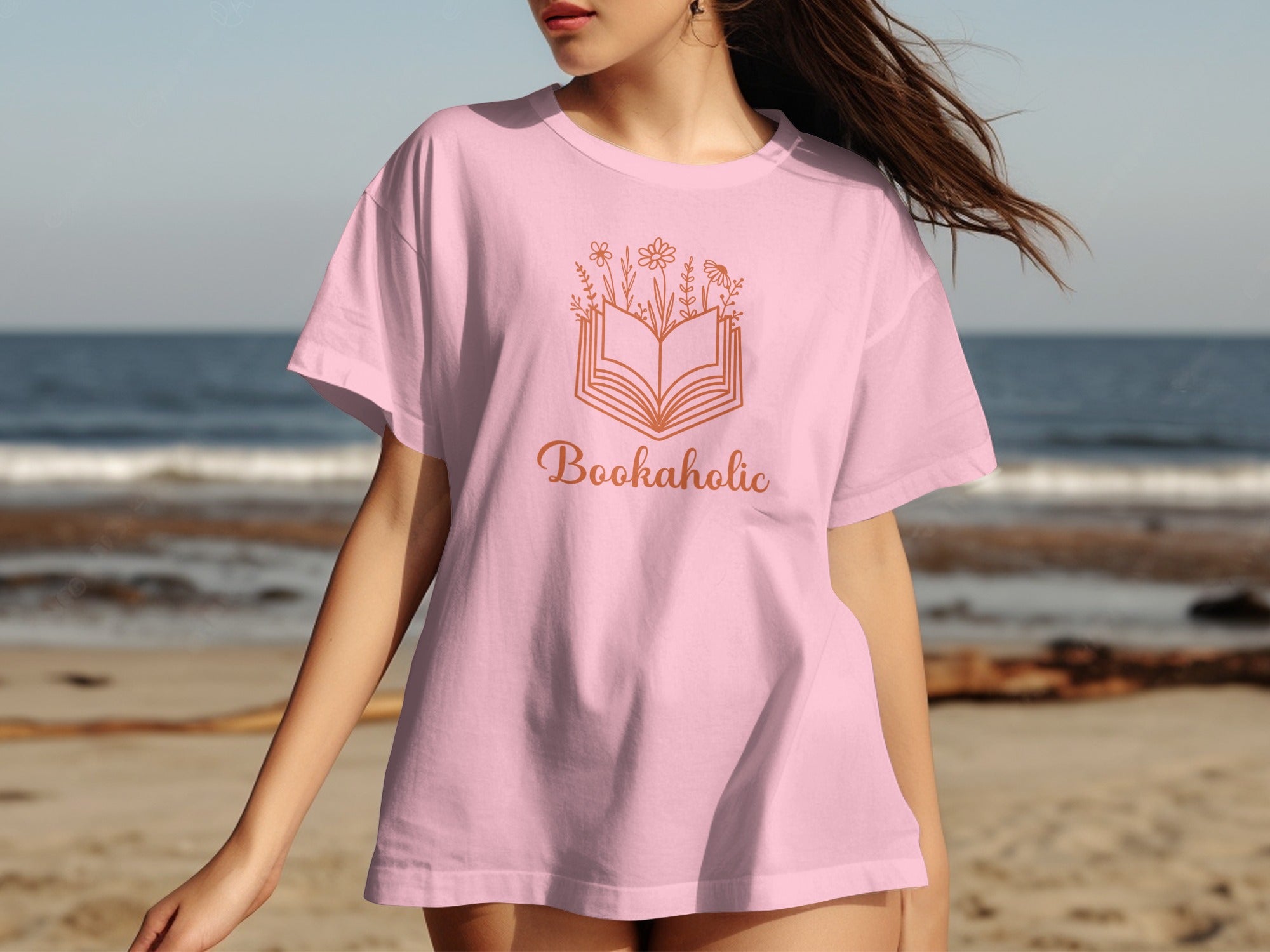 Pink t-shirt with "Bookaholic" text and an open book with floral design.