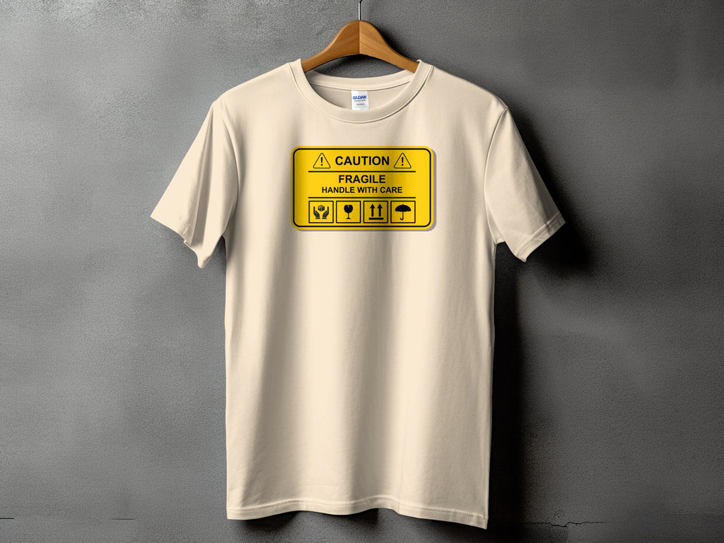 Cream t-shirt with "CAUTION FRAGILE HANDLE WITH CARE" and package symbols.