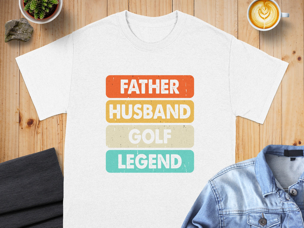 White t-shirt with 'Father Husband Golf Legend' text in stacked colored blocks.