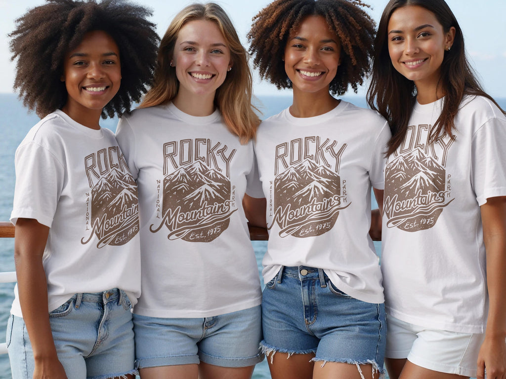 Four women wear white t-shirts with a brown Rocky Mountains National Park design.