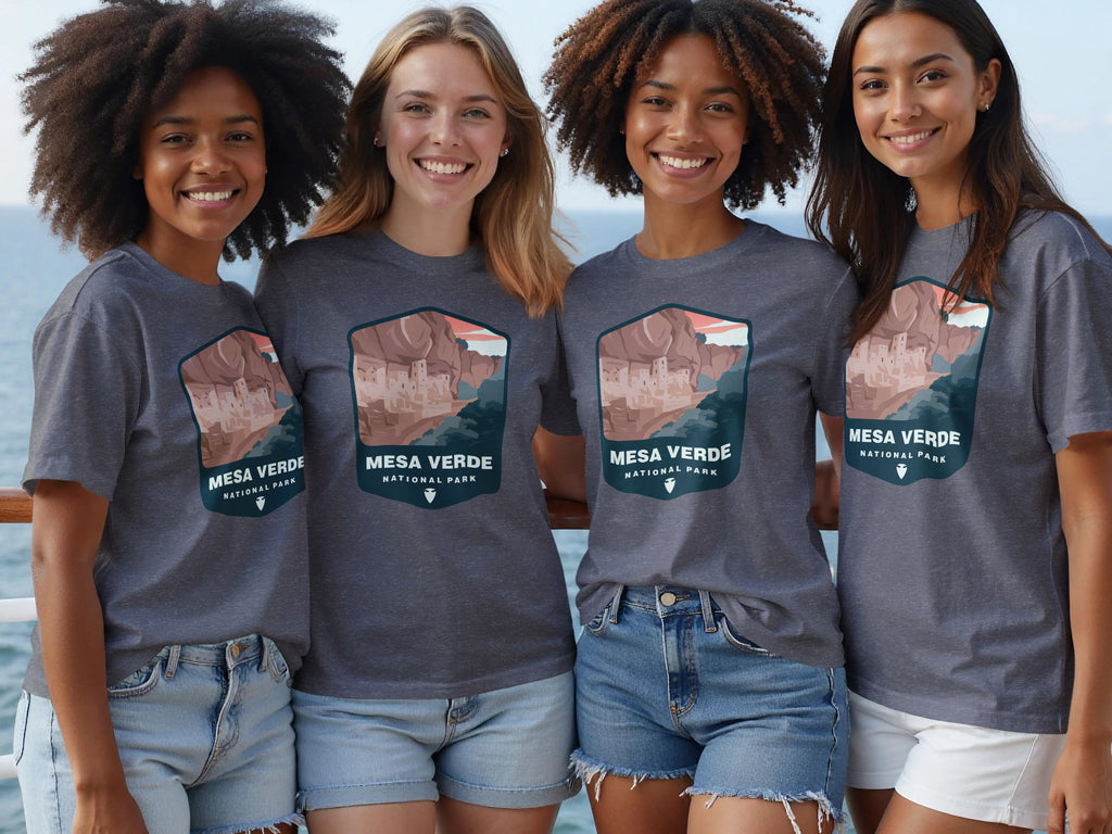 Four smiling young women wear t-shirts featuring a Mesa Verde National Park graphic.