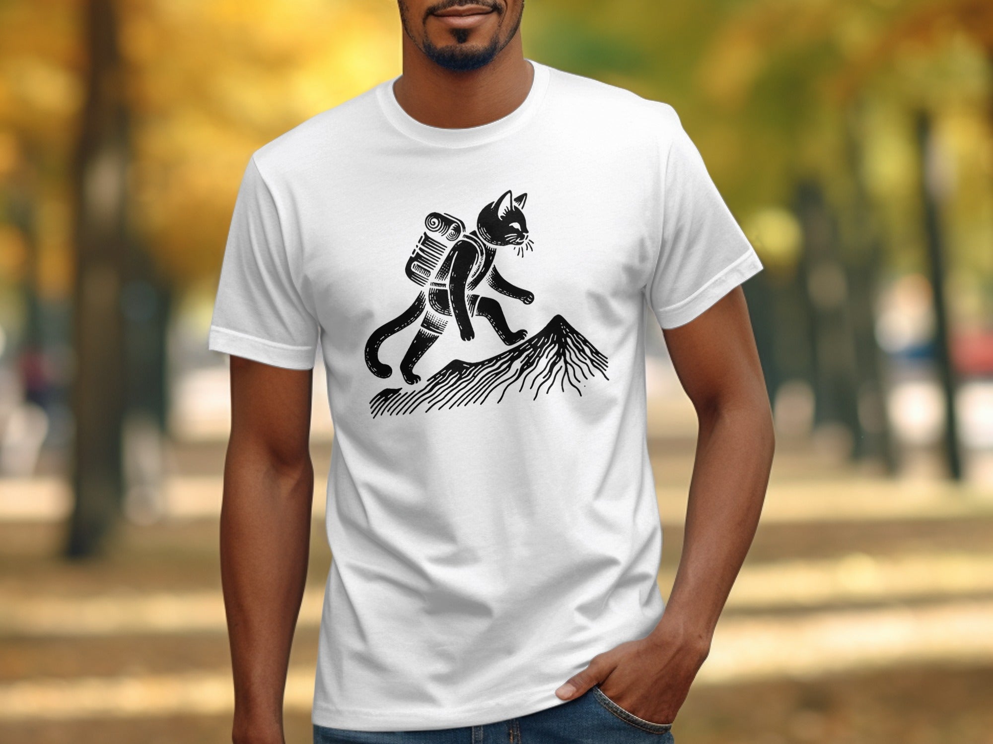 White t-shirt with black graphic of a cat hiking a mountain with a backpack.