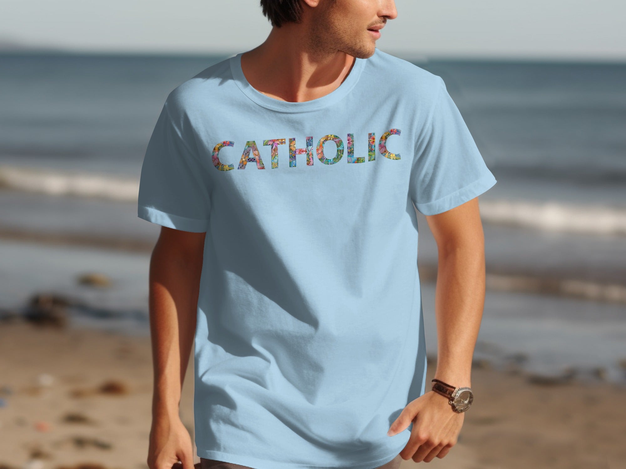 Light blue t-shirt with "CATHOLIC" text in colorful floral pattern.