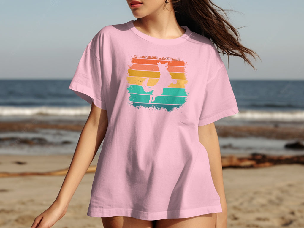 Pink t-shirt with a jumping dog silhouette on a retro striped background.