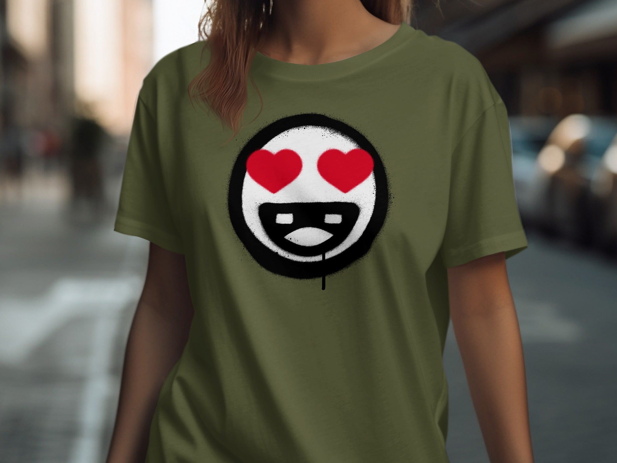 Green t-shirt with a spray-painted smiley face with red heart eyes and black teeth.