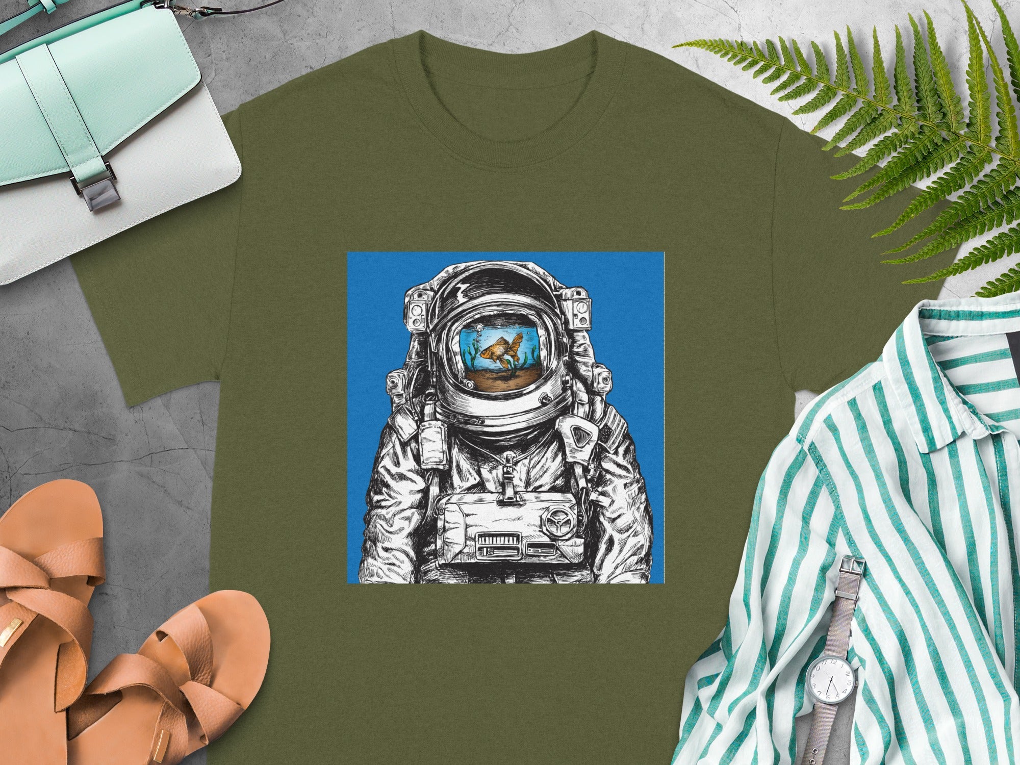 Astronaut with goldfish in helmet illustration on olive green t-shirt.