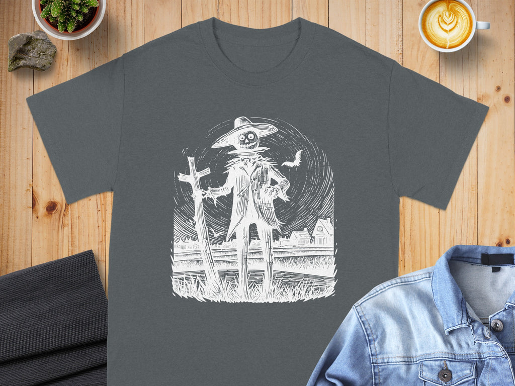Dark gray t-shirt with white scarecrow, fence, and houses illustration.