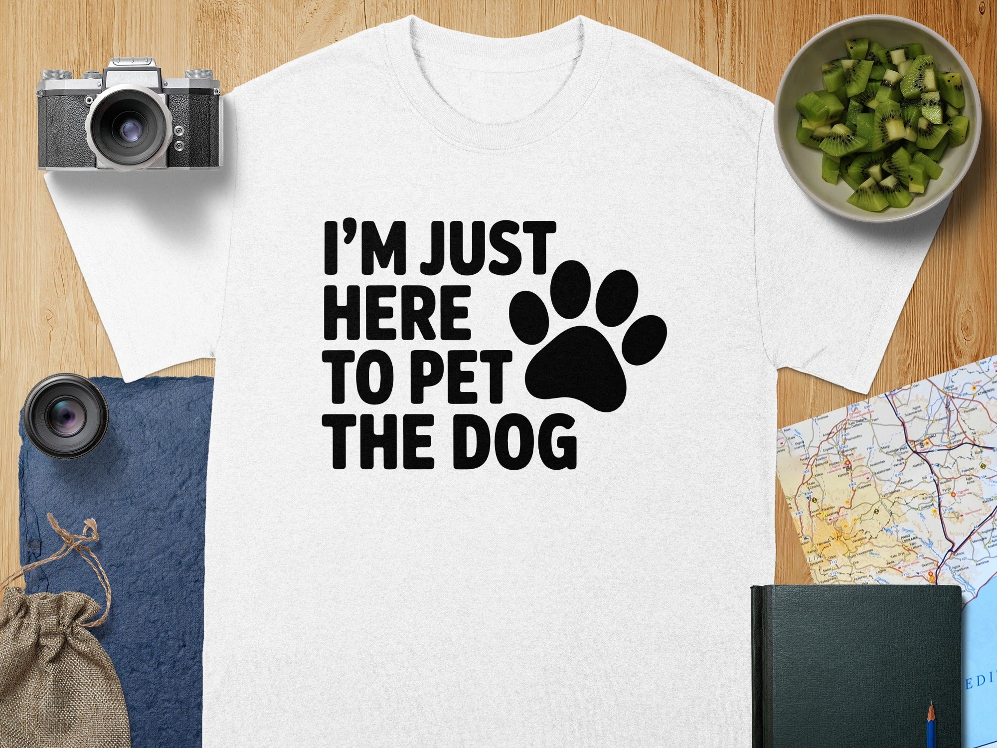 White t-shirt with black text "I'M JUST HERE TO PET THE DOG" and paw print.