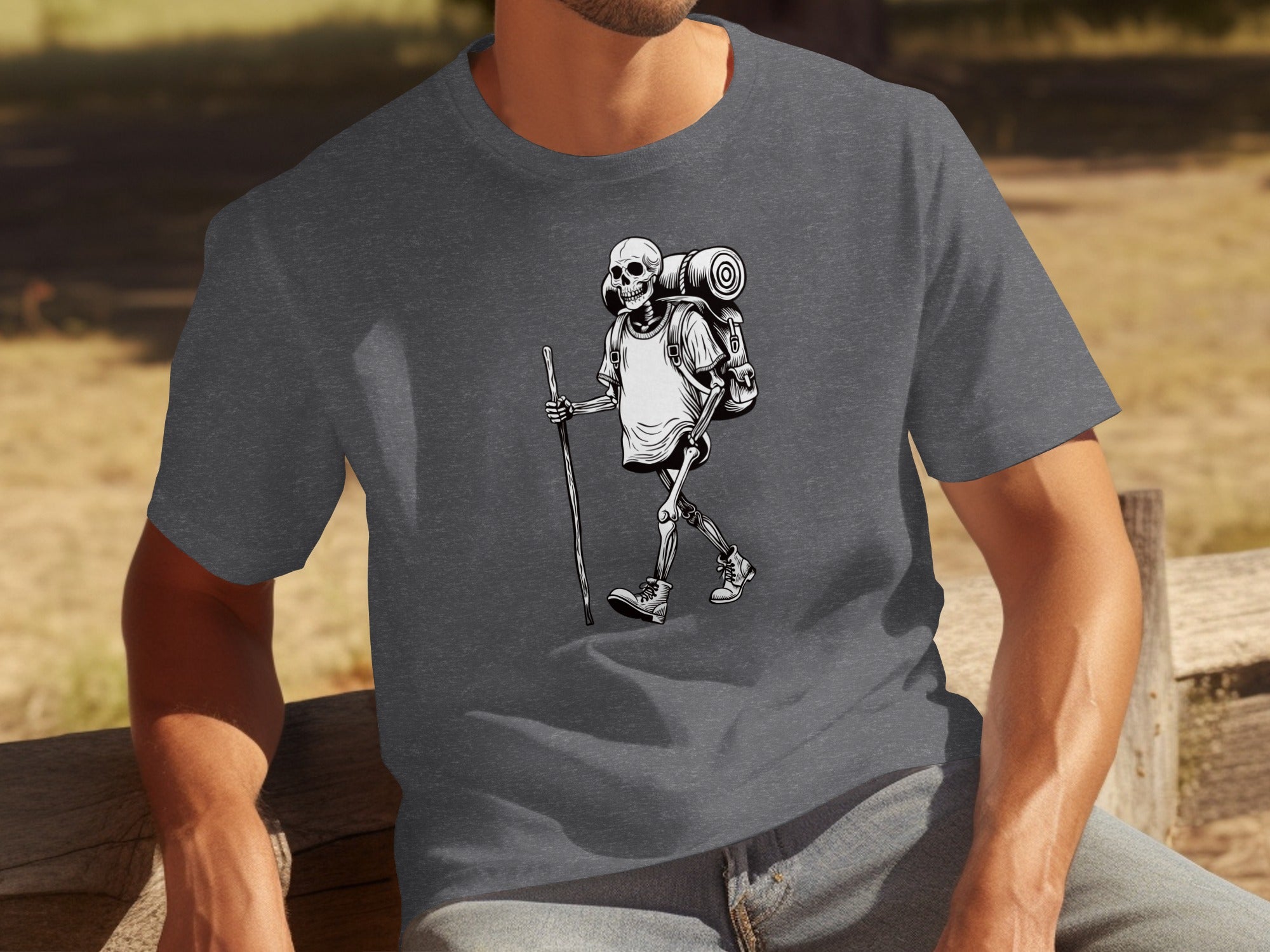 Skeleton hiker with backpack and walking stick, black and white illustration on t-shirt.