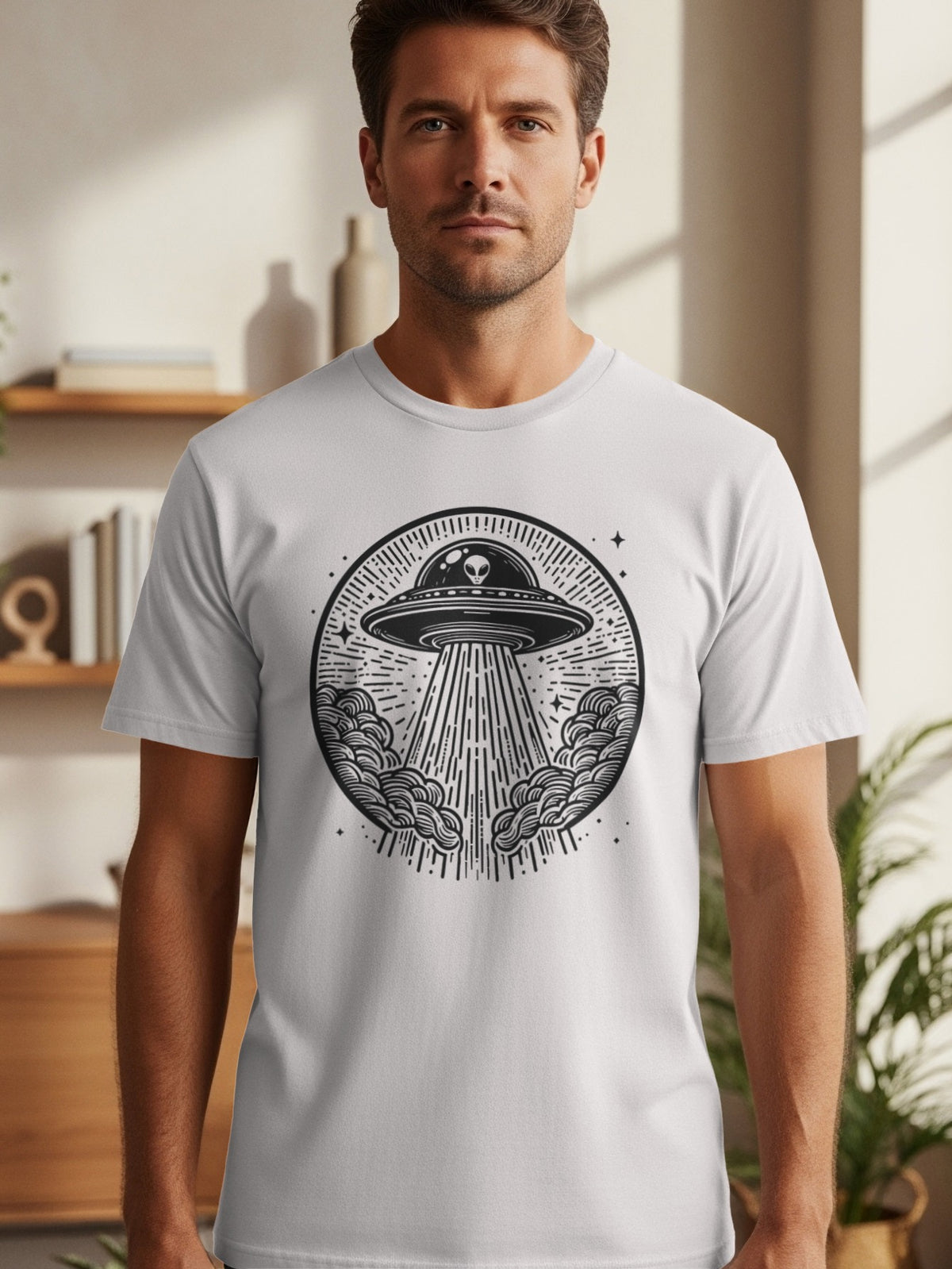 T-shirt featuring a black and white circular graphic of a UFO abducting a beam and clouds.