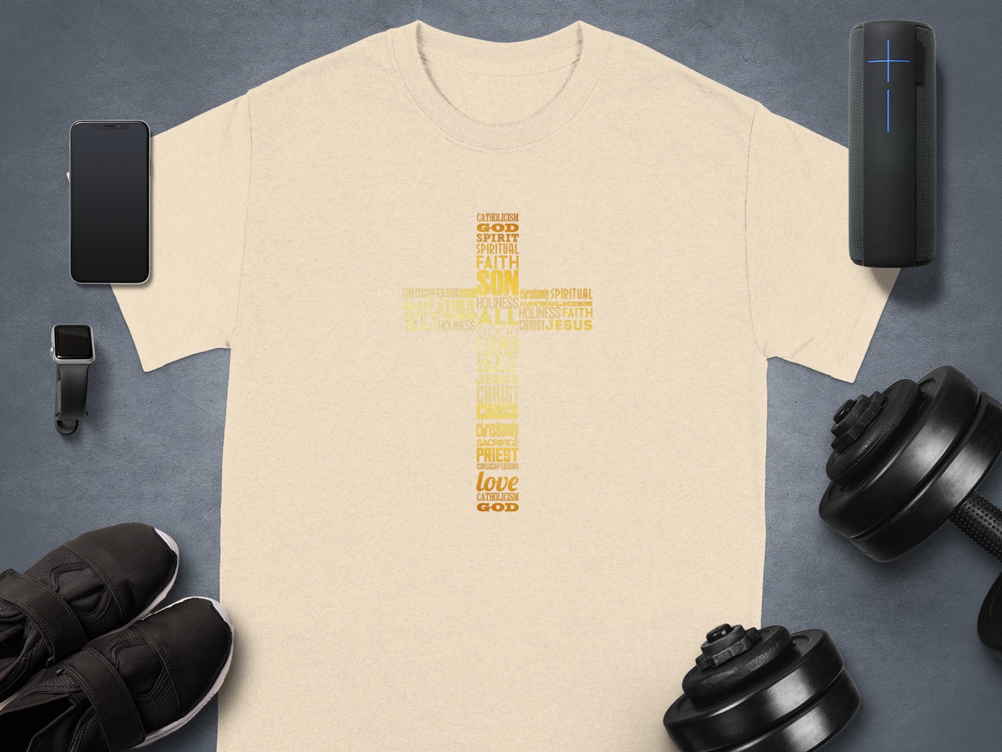 Light tan t-shirt with word art cross including Catholicism, God, Son, Jesus, Love.