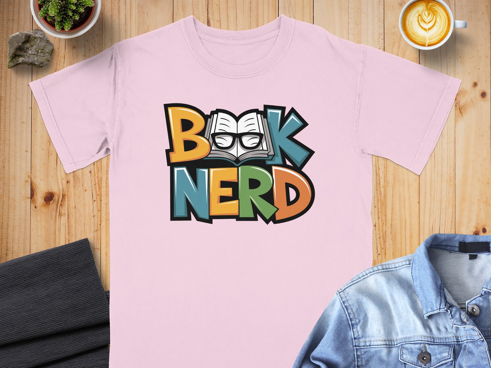 Pink t-shirt with "Book NERD" text featuring an open book and glasses.