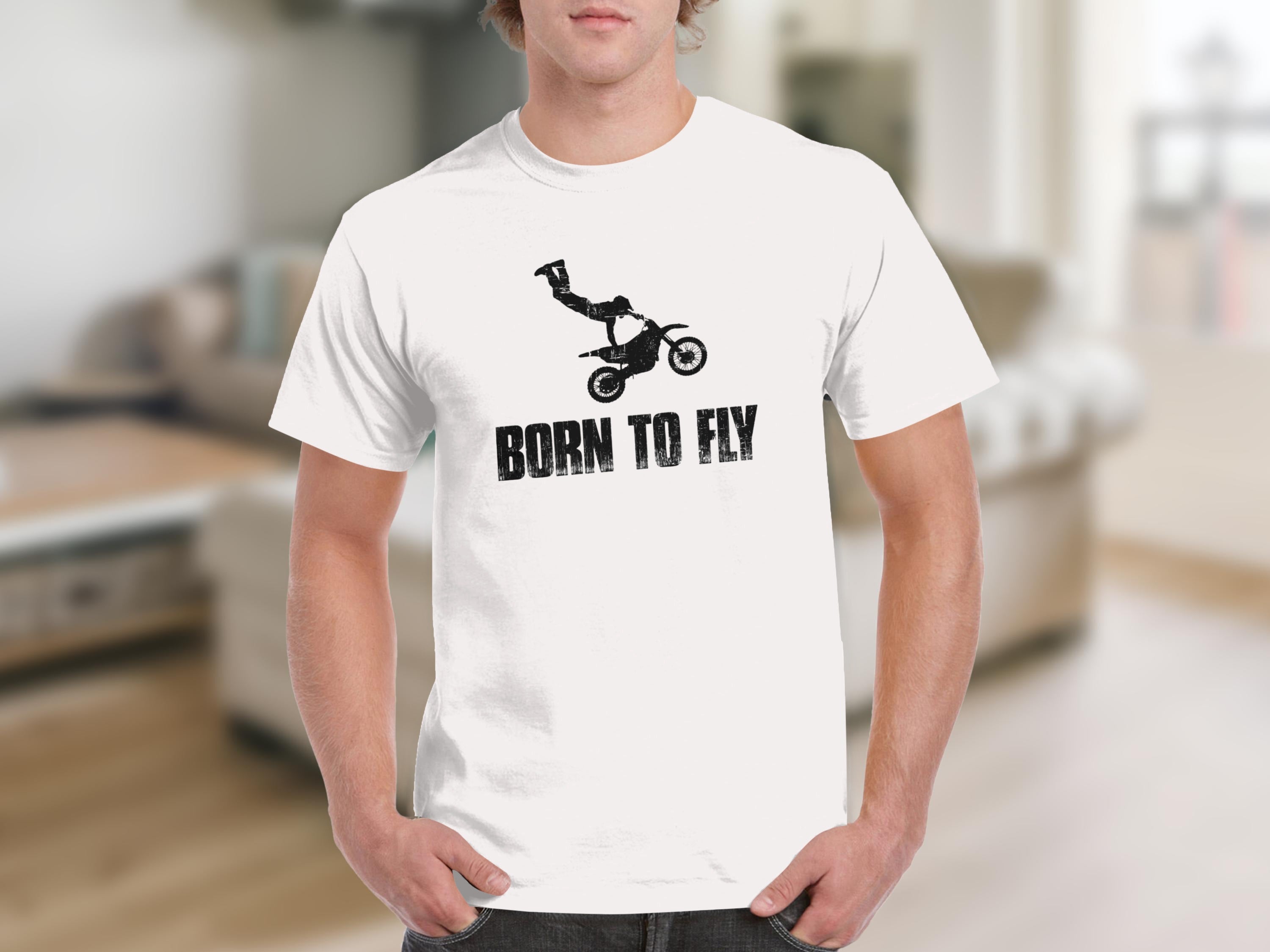 White t-shirt with black distressed graphic of a motocross rider doing a trick and text "BORN TO FLY".