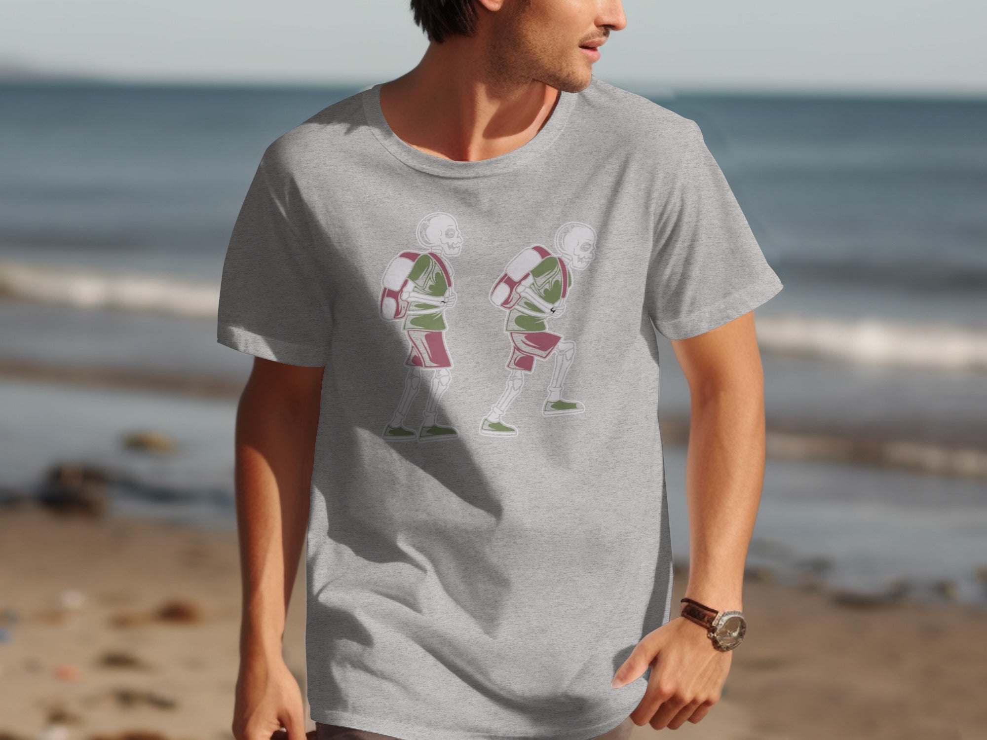 Grey t-shirt with graphic of two skeletons wearing backpacks and athletic shorts.