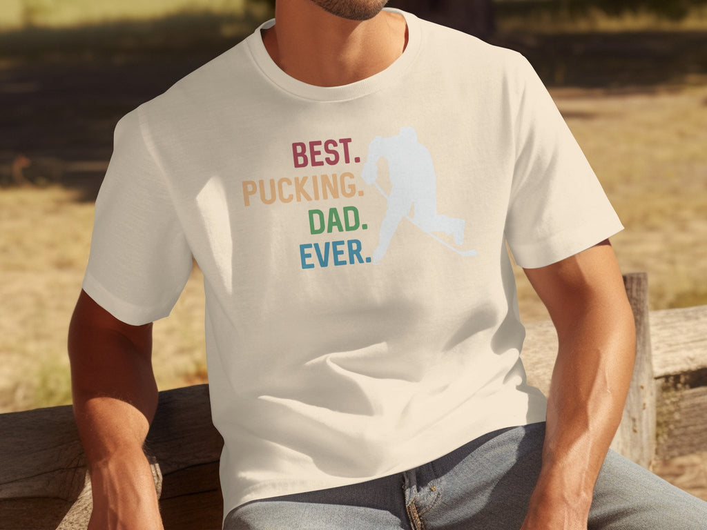 Cream t-shirt with "BEST. PUCKING. DAD. EVER." text and hockey player graphic.