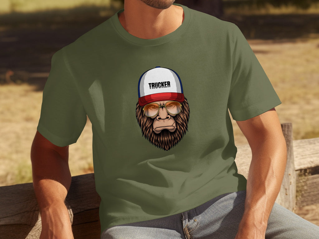 Bigfoot wearing glasses and a trucker hat graphic on a green t-shirt.