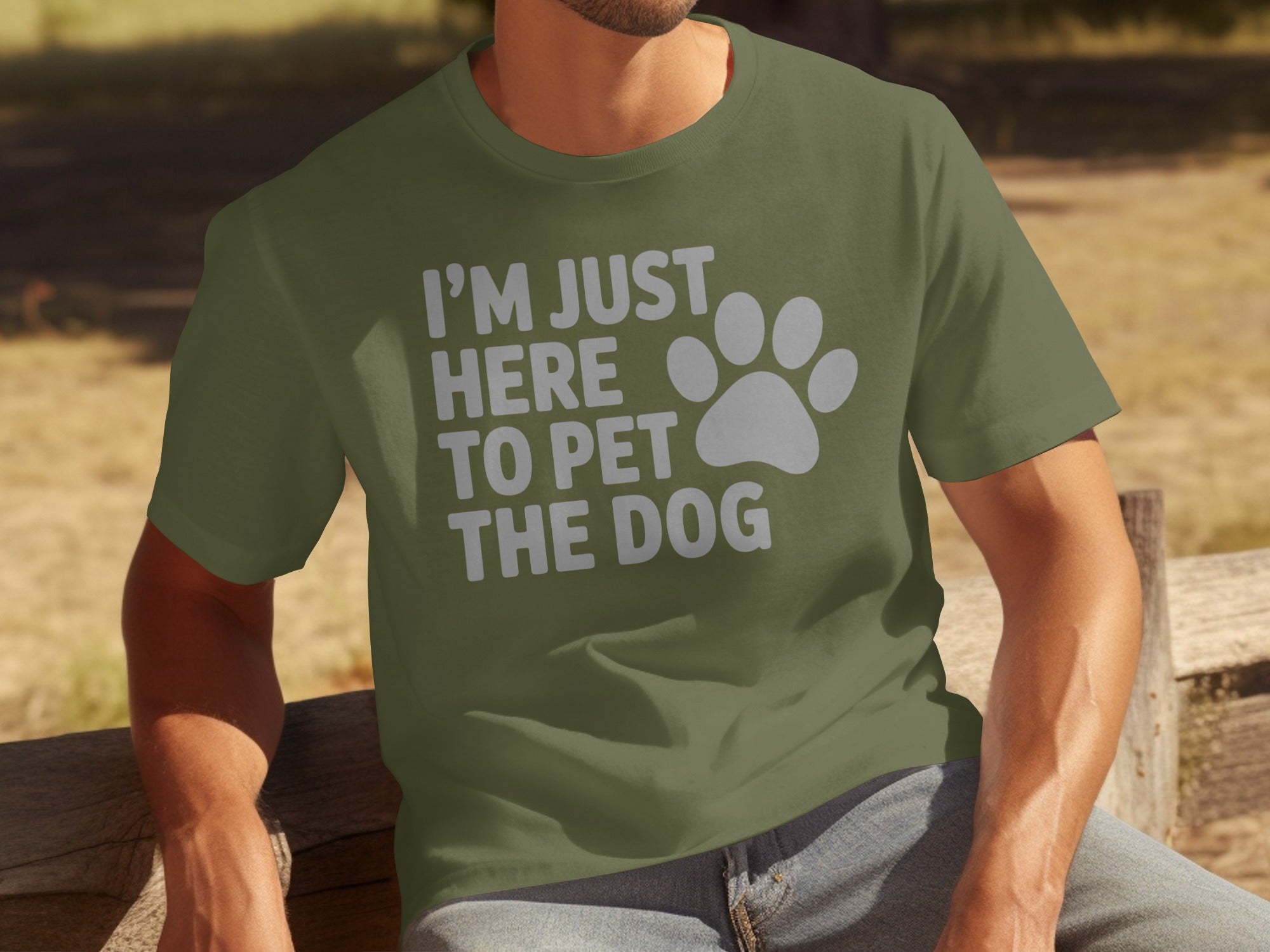 Green t-shirt with white text "I'M JUST HERE TO PET THE DOG" and paw print.