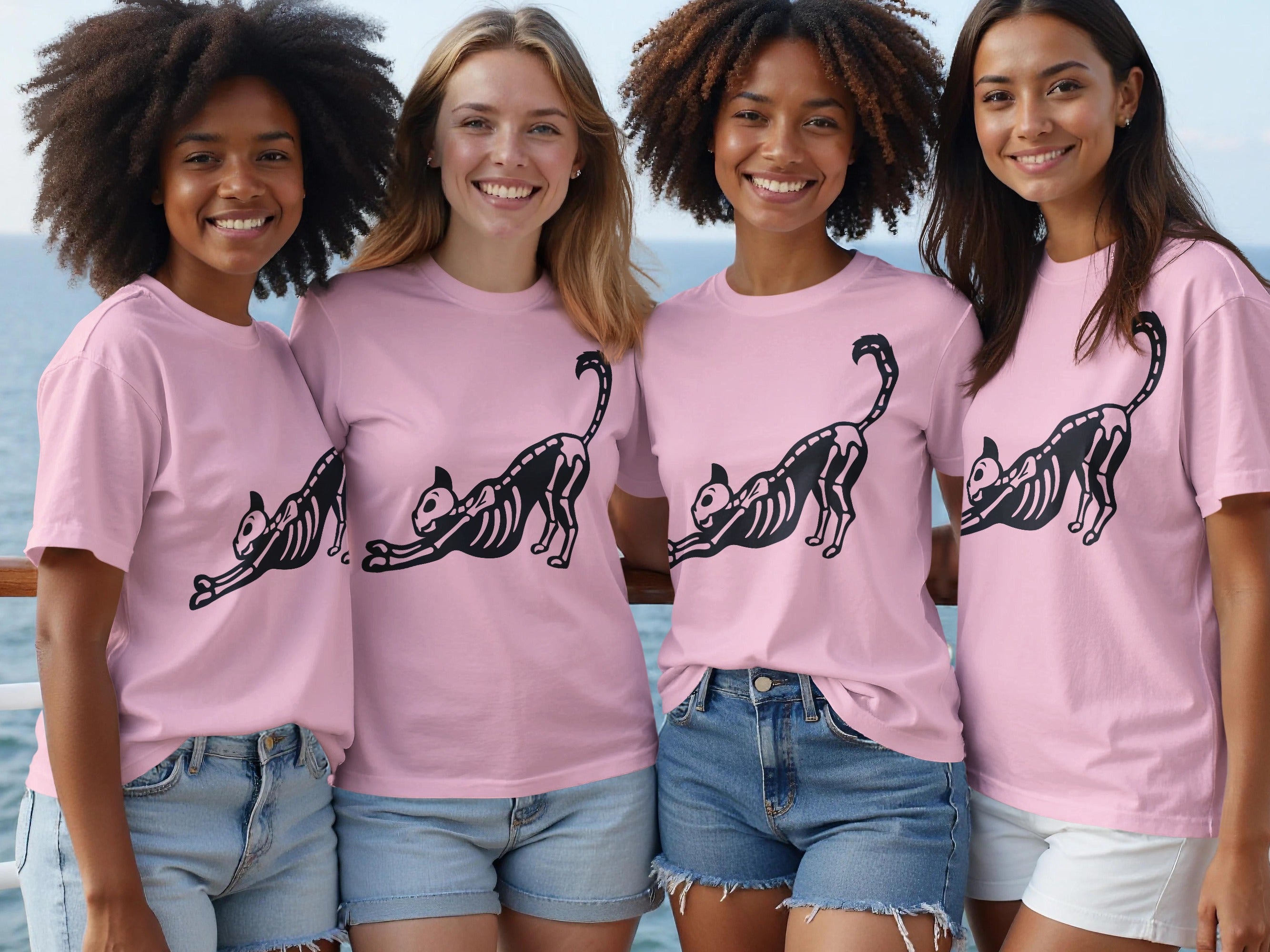 Four women wear pink t-shirts with a black skeleton cat graphic.