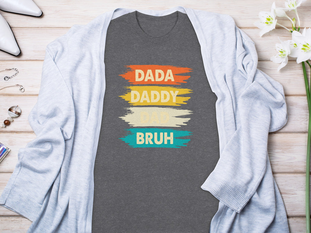 Dark gray t-shirt with colorful brush strokes and text "Dada Daddy Dad Bruh".