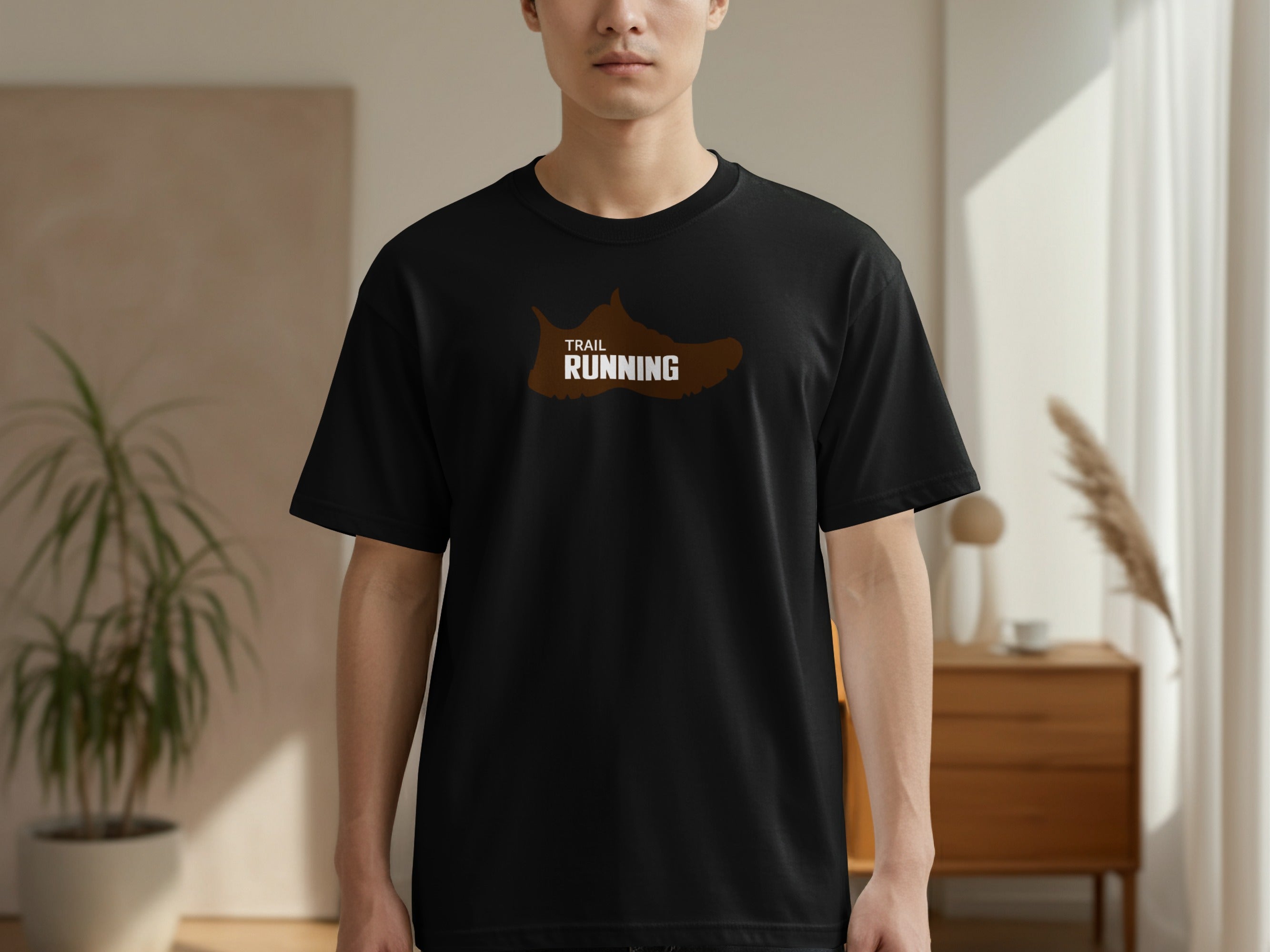 Black t-shirt with a brown trail running shoe graphic on the chest.