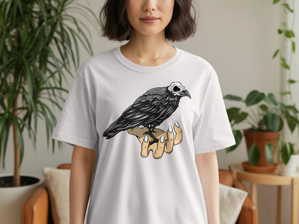 White t-shirt with a graphic of a crow with a skull for a head perched on a hand.