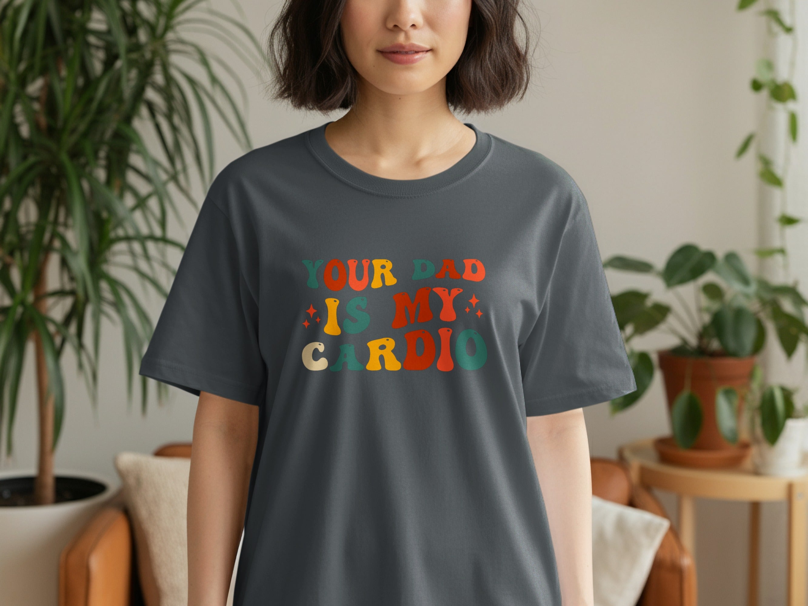 Dark grey t-shirt with retro text saying "YOUR DAD IS MY CARDIO".