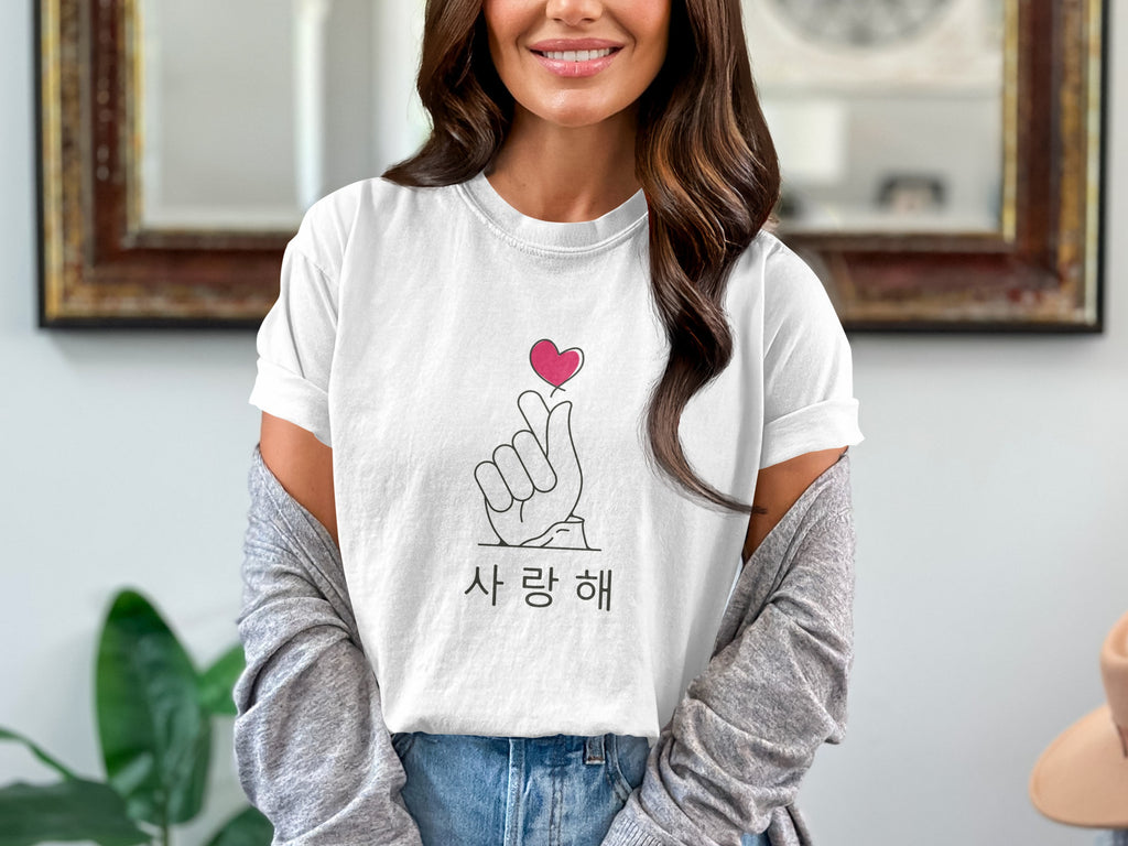 White t-shirt with a pink heart finger snap and Korean text reading "Saranghae".