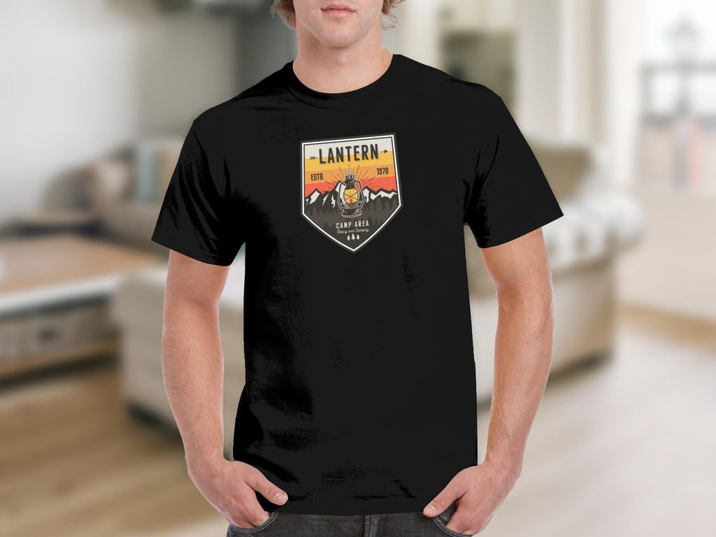 Black t-shirt with a shield design featuring a lantern, mountains, and the text "Lantern ESTB 1978".