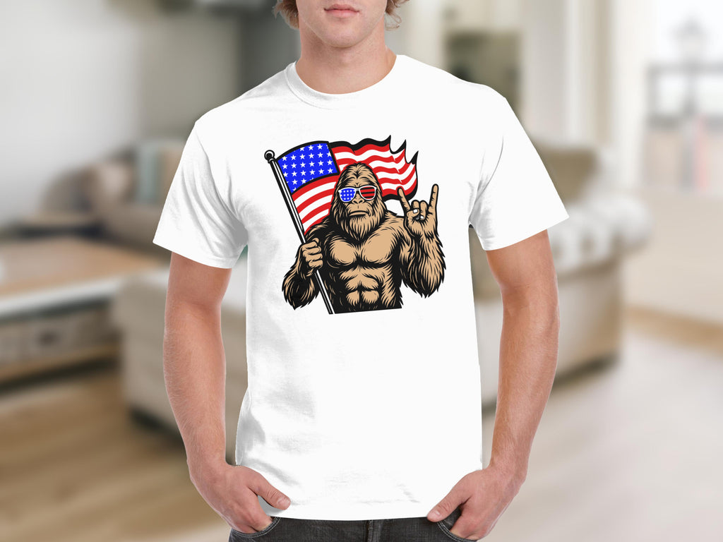 Bigfoot with American flag, sunglasses, and rock and roll hand gesture on t-shirt.