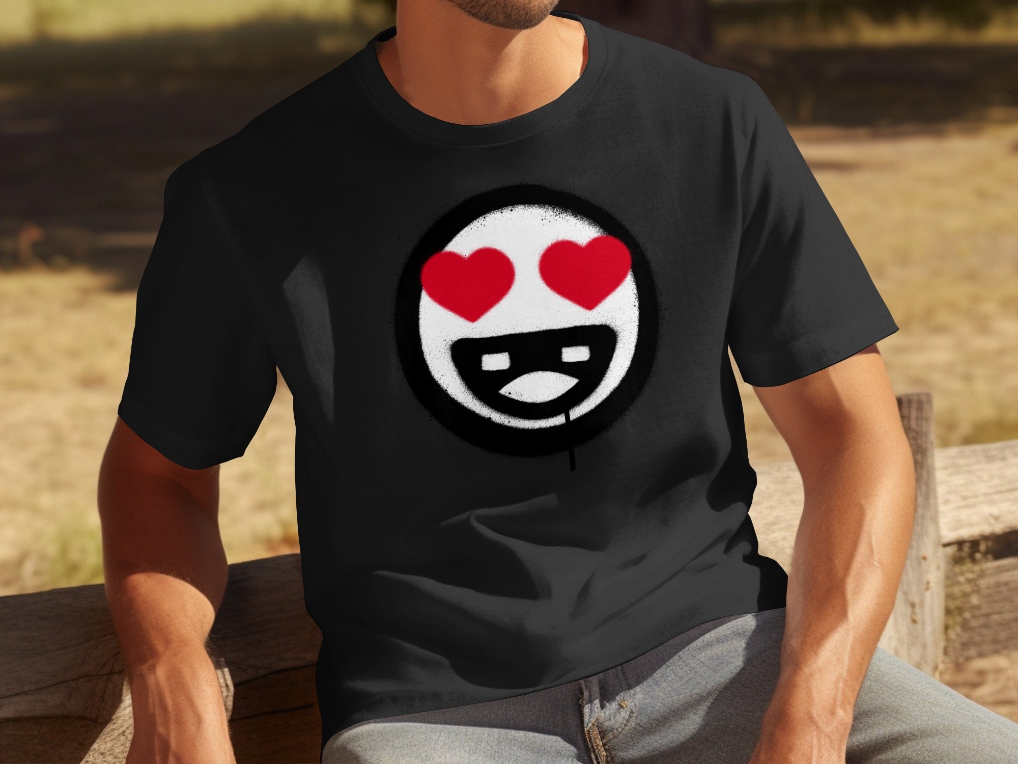 Black t-shirt with a white circle emblem featuring red heart eyes and a smiling mouth.