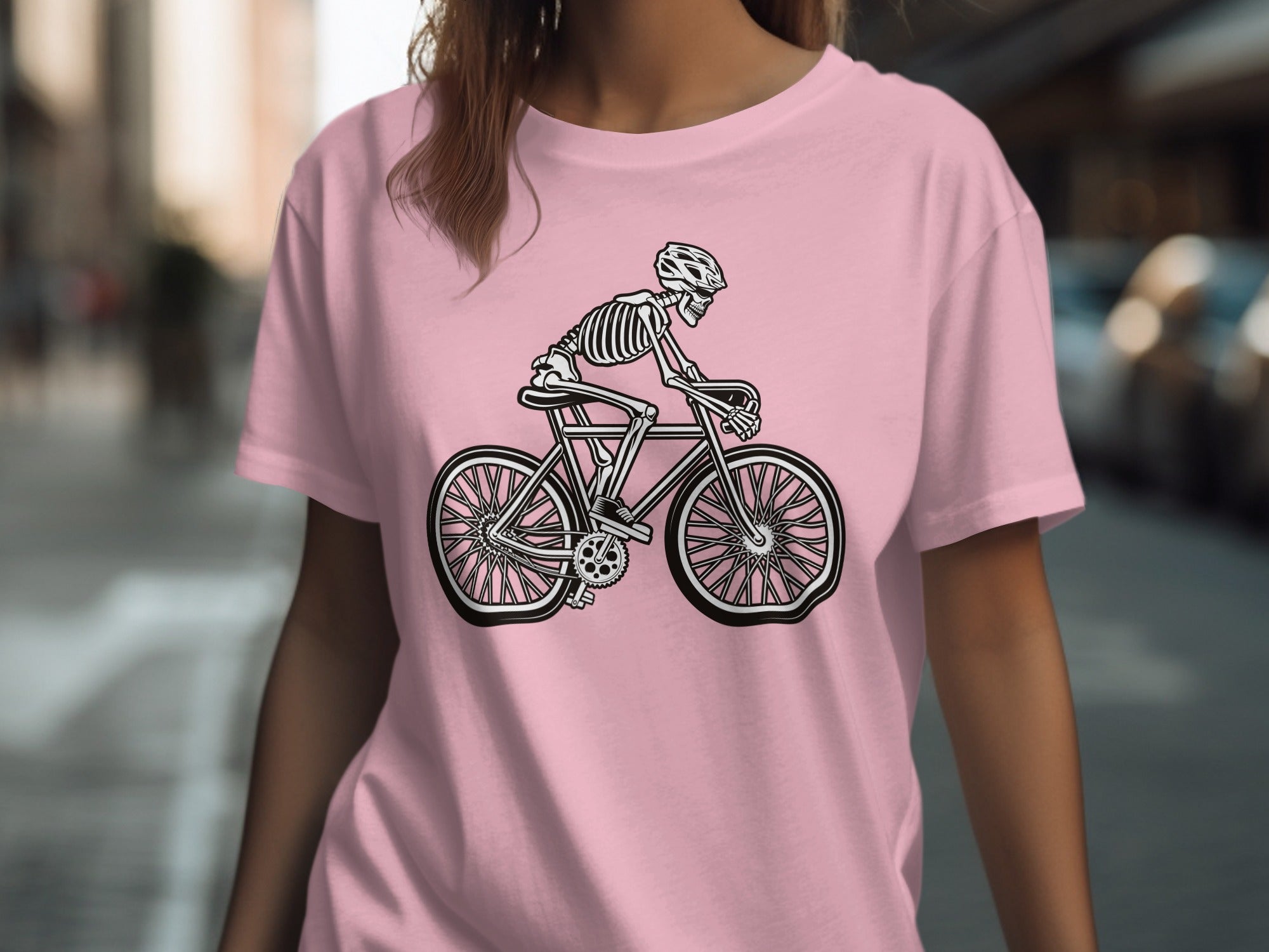 Pink t-shirt with black skeleton riding a bicycle graphic.