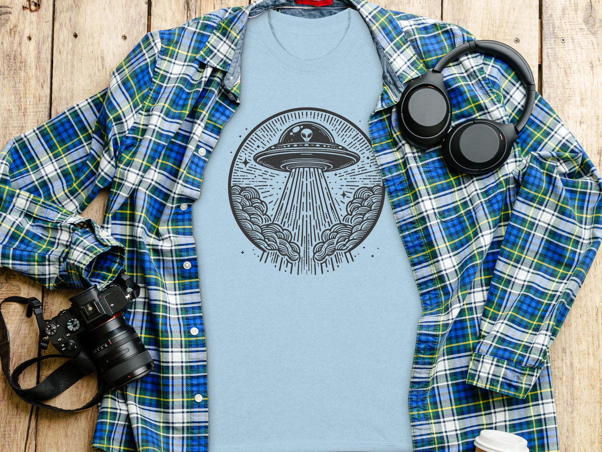 Light blue t-shirt with a circular alien abduction graphic and open plaid shirt.