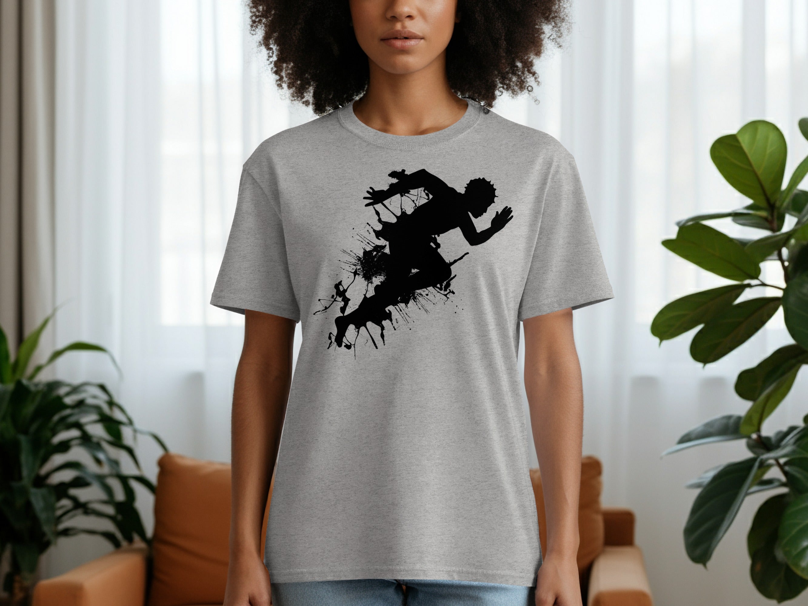 Grey t-shirt with black silhouette of running figure and ink splatters.