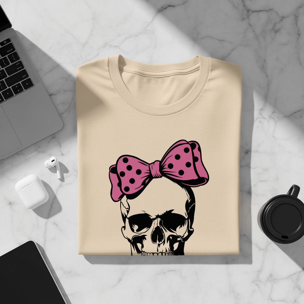 Beige t-shirt with a black and pink polka dot bow on a skull graphic.