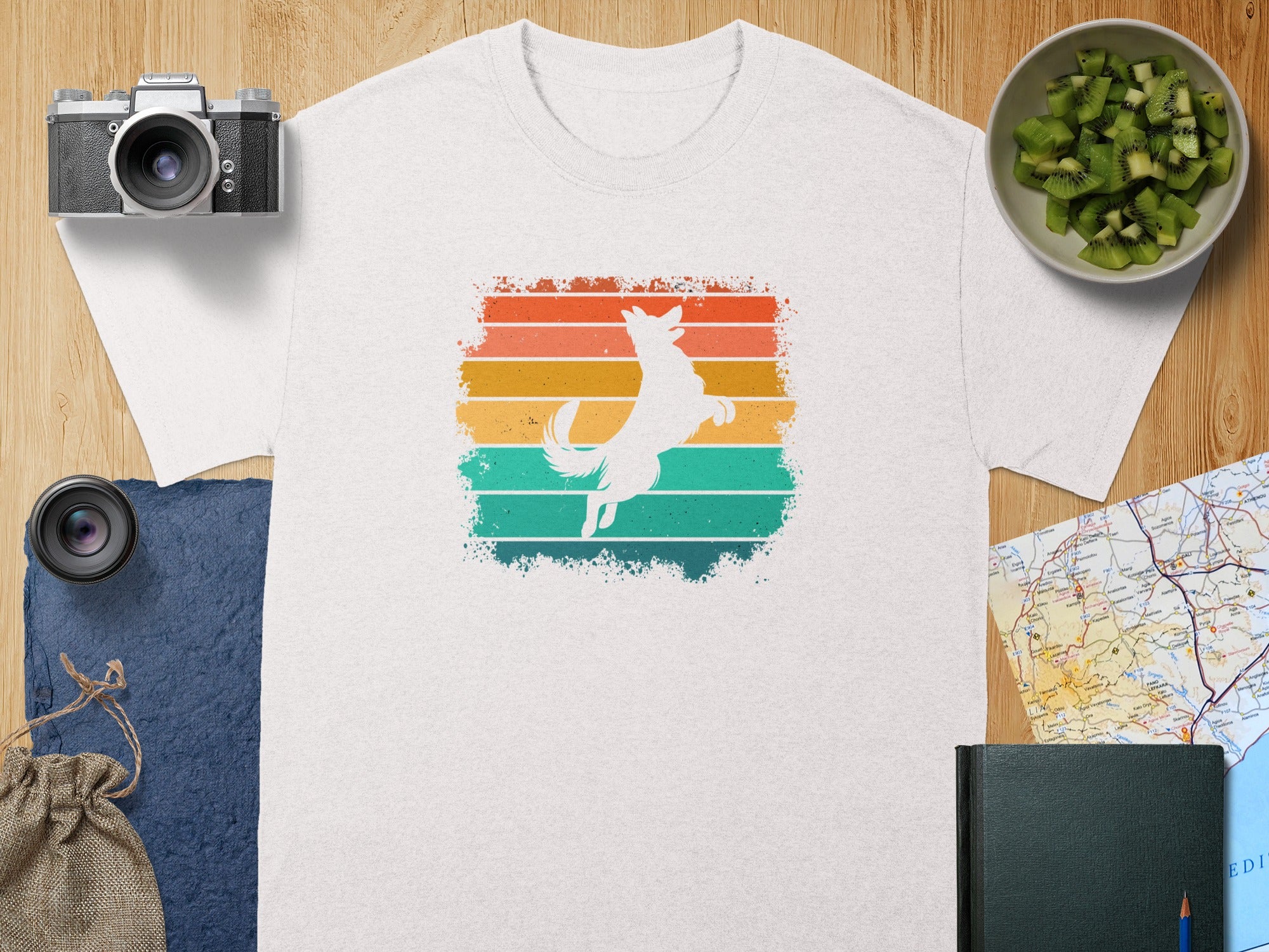 White t-shirt with a white dog silhouette jumping against a colorful striped background.