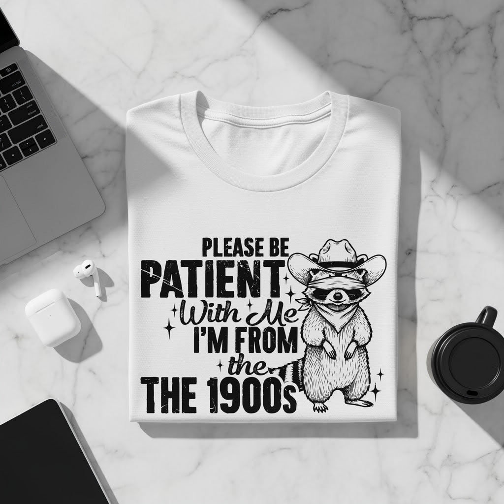 White t-shirt with a raccoon wearing a cowboy hat and bandana, with text.